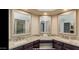 Elegant bathroom with double sinks, granite counters, and large mirrors at 13035 W Ballad W Dr, Sun City West, AZ 85375