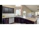 Modern kitchen with dark wood cabinets, granite countertops, and a tile backsplash at 13035 W Ballad W Dr, Sun City West, AZ 85375