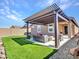 Pergola covered patio with seating area and artificial turf at 24614 N 169Th Dr, Surprise, AZ 85387