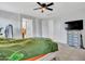 Main bedroom with a green duvet, ceiling fan, and dresser at 24614 N 169Th Dr, Surprise, AZ 85387