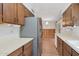 Galley kitchen with stainless steel refrigerator and wood cabinets at 4121 W Medlock Dr, Phoenix, AZ 85019