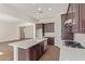 Open concept kitchen with island, white countertops and dark wood cabinets at 21033 E Camina Buena Vis, Queen Creek, AZ 85142
