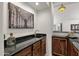 Wet bar with dark granite countertop and wood cabinets at 5542 E Anderson Dr, Scottsdale, AZ 85254