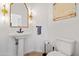 Stylish powder room with pedestal sink, gold mirror, and art piece at 8575 E Sharon Dr, Scottsdale, AZ 85260