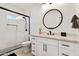 Modern bathroom with a large round mirror and walk-in shower at 8575 E Sharon Dr, Scottsdale, AZ 85260
