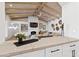 Modern kitchen with white cabinets and a view of the living area at 8575 E Sharon Dr, Scottsdale, AZ 85260
