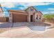 Single story home with stone and stucco exterior, and a brown garage door at 5719 E Sayan St, Mesa, AZ 85215