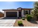 Charming house exterior with brown garage door and landscaping at 18767 W Canterbury Dr, Surprise, AZ 85388