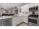 Modern kitchen with white cabinets, stainless steel appliances, and quartz countertops at 18767 W Canterbury Dr, Surprise, AZ 85388