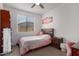Well-lit bedroom with a queen bed and desk at 18767 W Canterbury Dr, Surprise, AZ 85388