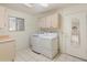 Laundry room with washer, dryer, cabinets and tiled floor at 8737 W Kimberly Way, Peoria, AZ 85382