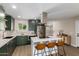 Modern kitchen with dark green cabinets, quartz countertops, and island seating at 7508 E Beatrice St, Scottsdale, AZ 85257