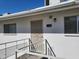 Building entrance with a metal security door and a railing at 825 N Hayden Rd # C207, Scottsdale, AZ 85257