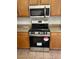 Stainless steel stove and microwave in a kitchen with wood cabinets at 3027 W Red Fox Rd, Phoenix, AZ 85083