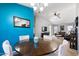 Dining area with a round table and chairs, teal accent wall, and view of living room at 38169 N Rusty Ln, San Tan Valley, AZ 85140