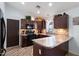 Well-equipped kitchen with dark wood cabinets and a breakfast bar at 38169 N Rusty Ln, San Tan Valley, AZ 85140