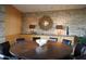 Elegant dining room features a large round table, stone wall, and modern light fixtures at 10801 E Happy Valley Rd # 132, Scottsdale, AZ 85255