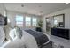 Main bedroom with gray upholstered bed and ensuite bathroom at 17978 W Long Lake Rd, Goodyear, AZ 85338