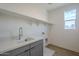 Laundry room with sink, cabinets, and washer/dryer hookups at 17978 W Long Lake Rd, Goodyear, AZ 85338