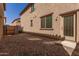 Small gravel backyard with a wooden fence and access door at 913 E Agua Fria Ln, Avondale, AZ 85323