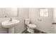 Clean and functional bathroom with pedestal sink and toilet at 913 E Agua Fria Ln, Avondale, AZ 85323