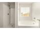 Bathroom with shower and bathtub, featuring a window for natural light at 913 E Agua Fria Ln, Avondale, AZ 85323