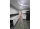Bright kitchen with white cabinets, quartz countertops and gray tile flooring, open to other areas at 4330 W Mescal St, Glendale, AZ 85304