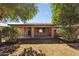 Covered patio and grassy backyard with mature trees at 14588 W Laurel Ln, Surprise, AZ 85379