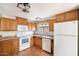 Kitchen boasts wood cabinets, white appliances, and laminate flooring at 9302 E Broadway Rd # 42, Mesa, AZ 85208