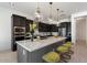 Modern kitchen features dark cabinetry, quartz countertops, and a large island with seating at 9622 W Villa Chula Dr, Peoria, AZ 85383