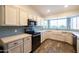 Modern kitchen with white cabinets, light blue backsplash, and a farmhouse sink at 2057 E Marquette Dr, Gilbert, AZ 85234