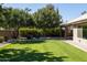 Landscaped backyard, grassy lawn, fire pit, and patio area at 2057 E Marquette Dr, Gilbert, AZ 85234