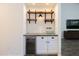 Built-in wet bar with a beverage cooler, sink, and rustic wooden shelving at 2057 E Marquette Dr, Gilbert, AZ 85234