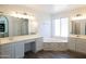 Spa-like bathroom with double vanity, soaking tub, and updated flooring at 2057 E Marquette Dr, Gilbert, AZ 85234
