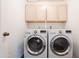 Bright laundry room with washer, dryer, and ample cabinet storage at 2057 E Marquette Dr, Gilbert, AZ 85234