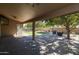 Covered patio with seating area, grassy backyard, and mature trees at 2057 E Marquette Dr, Gilbert, AZ 85234