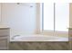 Bathroom with large corner soaking tub and updated tile at 2057 E Marquette Dr, Gilbert, AZ 85234