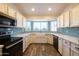 Modern kitchen with white cabinets, light blue backsplash, and a farmhouse sink at 2057 E Marquette Dr, Gilbert, AZ 85234