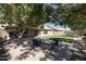 House exterior with grassy backyard, patio, and mature trees at 2057 E Marquette Dr, Gilbert, AZ 85234