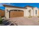 Two-car garage with brown doors and brick driveway at 726 E Citrus Hollow Way, Queen Creek, AZ 85140