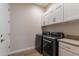 Bright laundry room, washer, dryer, and cabinets at 726 E Citrus Hollow Way, Queen Creek, AZ 85140
