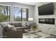 Living room with large windows, comfortable seating, and stone fireplace at 7700 E Gainey Ranch Rd # 206, Scottsdale, AZ 85258