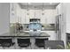 Modern kitchen with white cabinets, breakfast bar, and stainless steel appliances at 7700 E Gainey Ranch Rd # 206, Scottsdale, AZ 85258