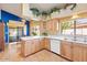 Modern kitchen with wood cabinets, island, and view to backyard at 19132 N 95Th Ave, Peoria, AZ 85382