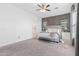 Relaxing main bedroom featuring a ceiling fan, large windows, and plush carpeting at 12379 W Chase Ln, Avondale, AZ 85323