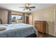 Bedroom with large window, ceiling fan and wood dresser at 11451 N 103Rd Ave, Sun City, AZ 85351