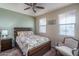 Bedroom with a wooden bed frame, chair, and two windows at 26404 W Zachary Dr, Buckeye, AZ 85396