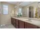 Bathroom with double sinks, large mirror, and plenty of cabinet space at 26404 W Zachary Dr, Buckeye, AZ 85396