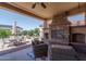 Relaxing covered patio with a stone fireplace and comfortable seating area at 26404 W Zachary Dr, Buckeye, AZ 85396