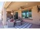 Covered patio with fireplace, seating, and views of the backyard at 26404 W Zachary Dr, Buckeye, AZ 85396